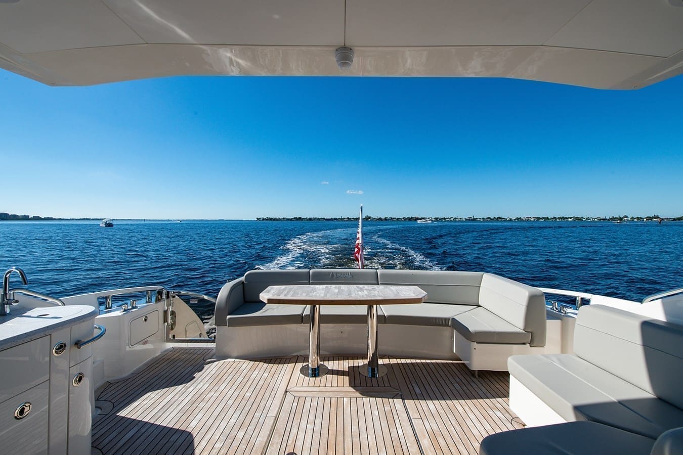 Aft deck dining table with the wake trailing behind