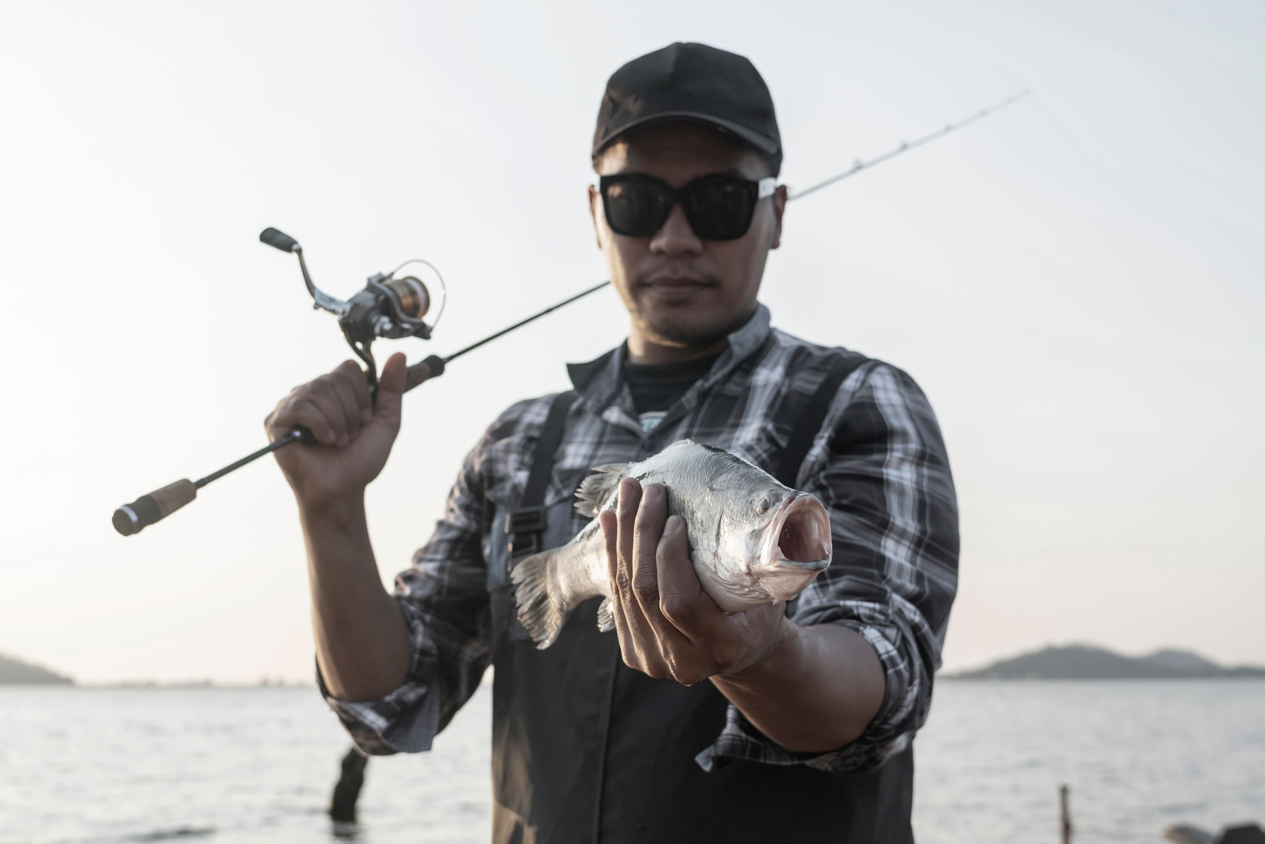 Captain Edward holding up a fresh catch at the waterline