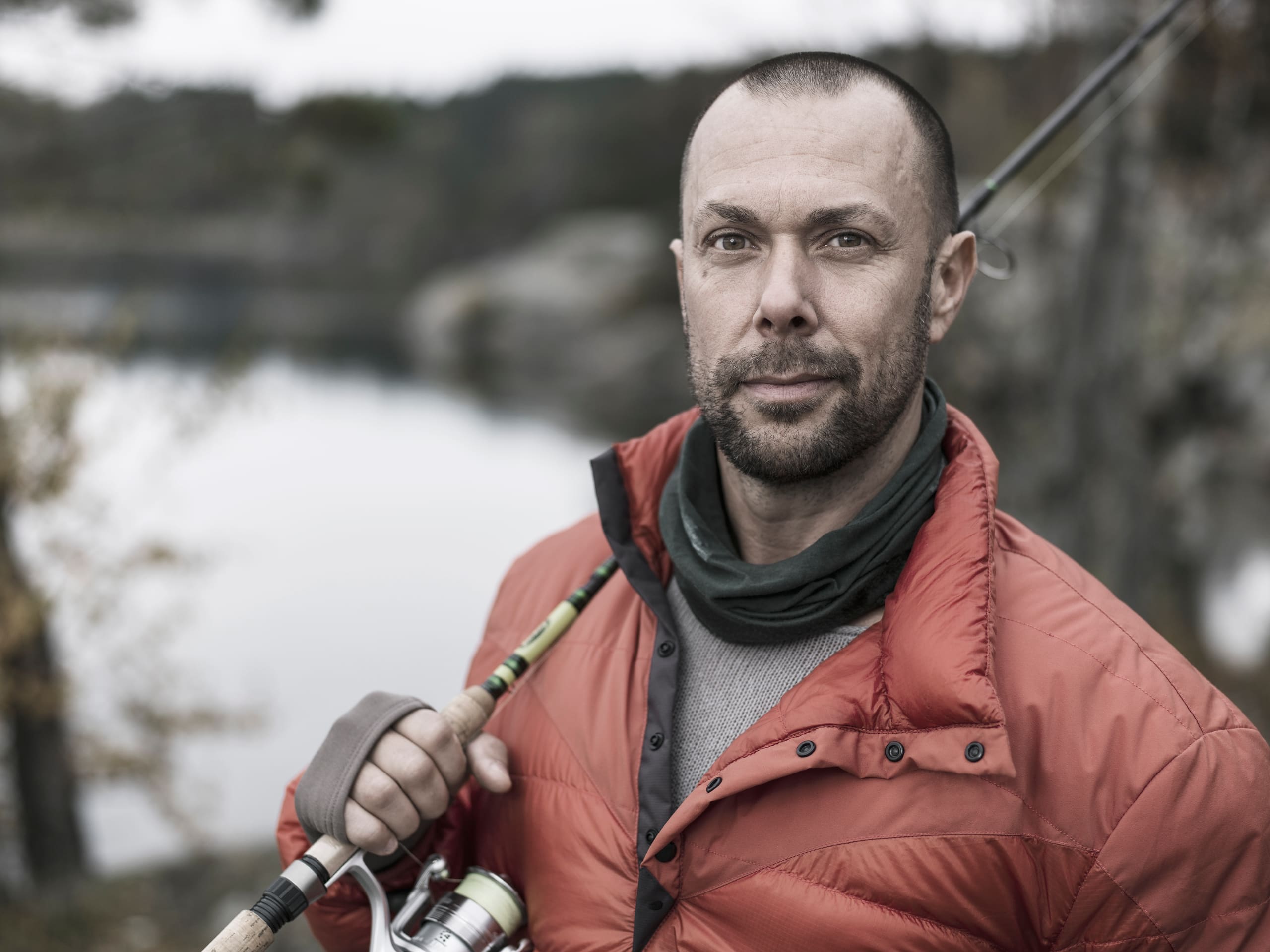 Captain John with a rod over his shoulder beside a still inlet