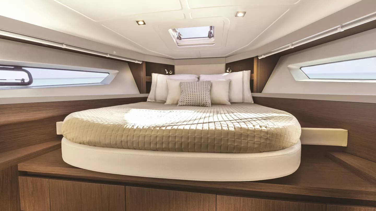 Forward cabin berth with warm wood joinery