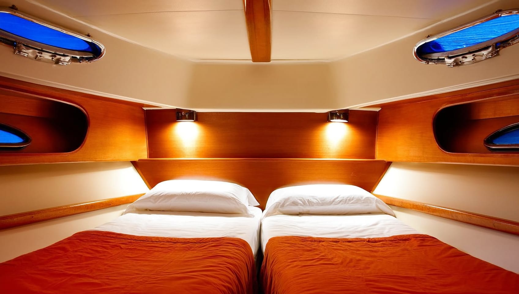 Twin guest cabin with reading lights and warm wood joinery