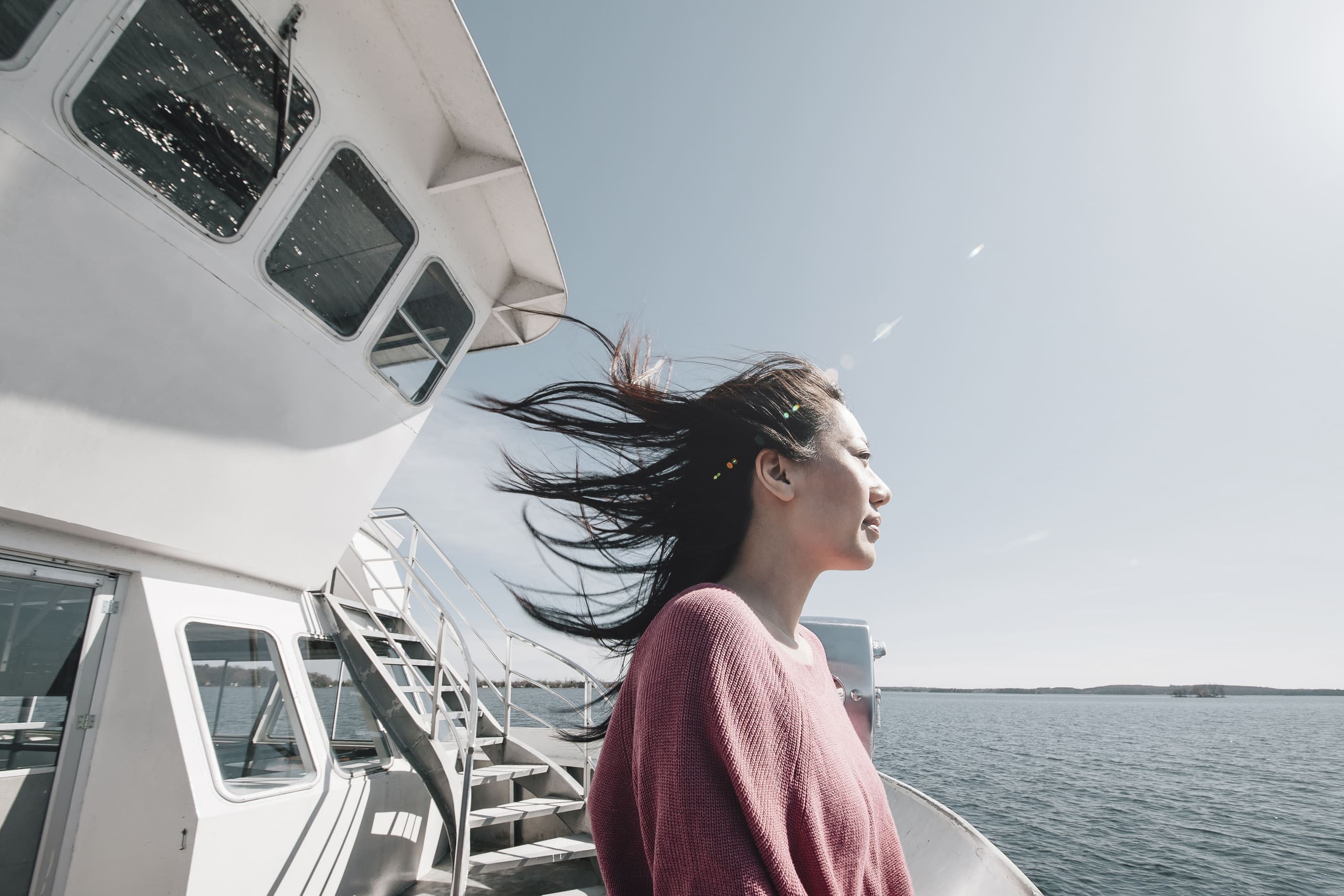 A guest at the rail taking in the sea breeze during a charter cruise