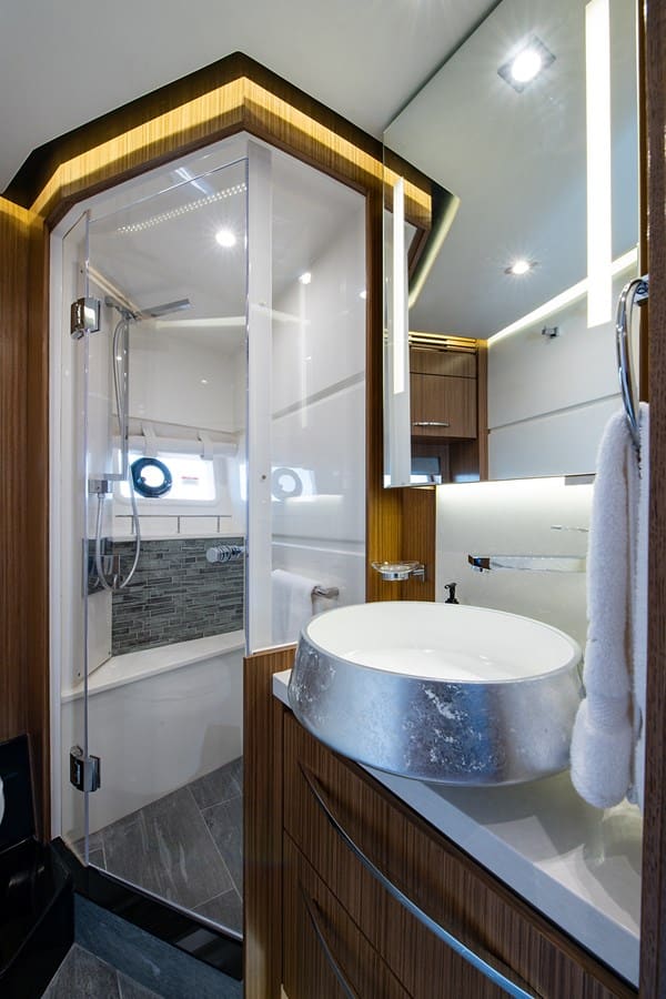 Ensuite head with a glass-enclosed shower and stone vessel sink