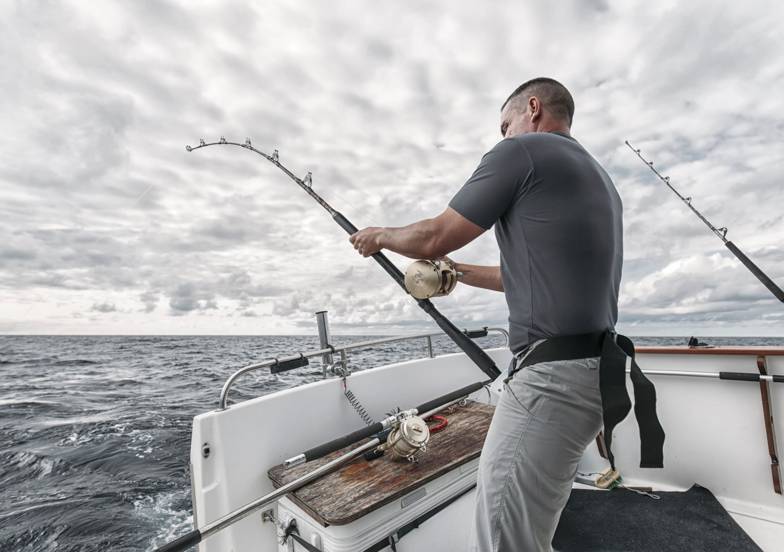 Working the rods off the stern under a wide grey sky